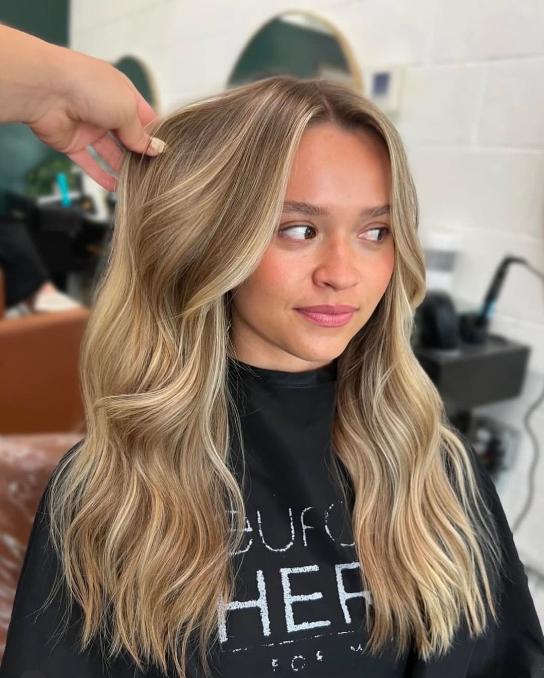 Long, wavy blonde hair styled at a salon, showcasing a fresh haircut and natural highlights.