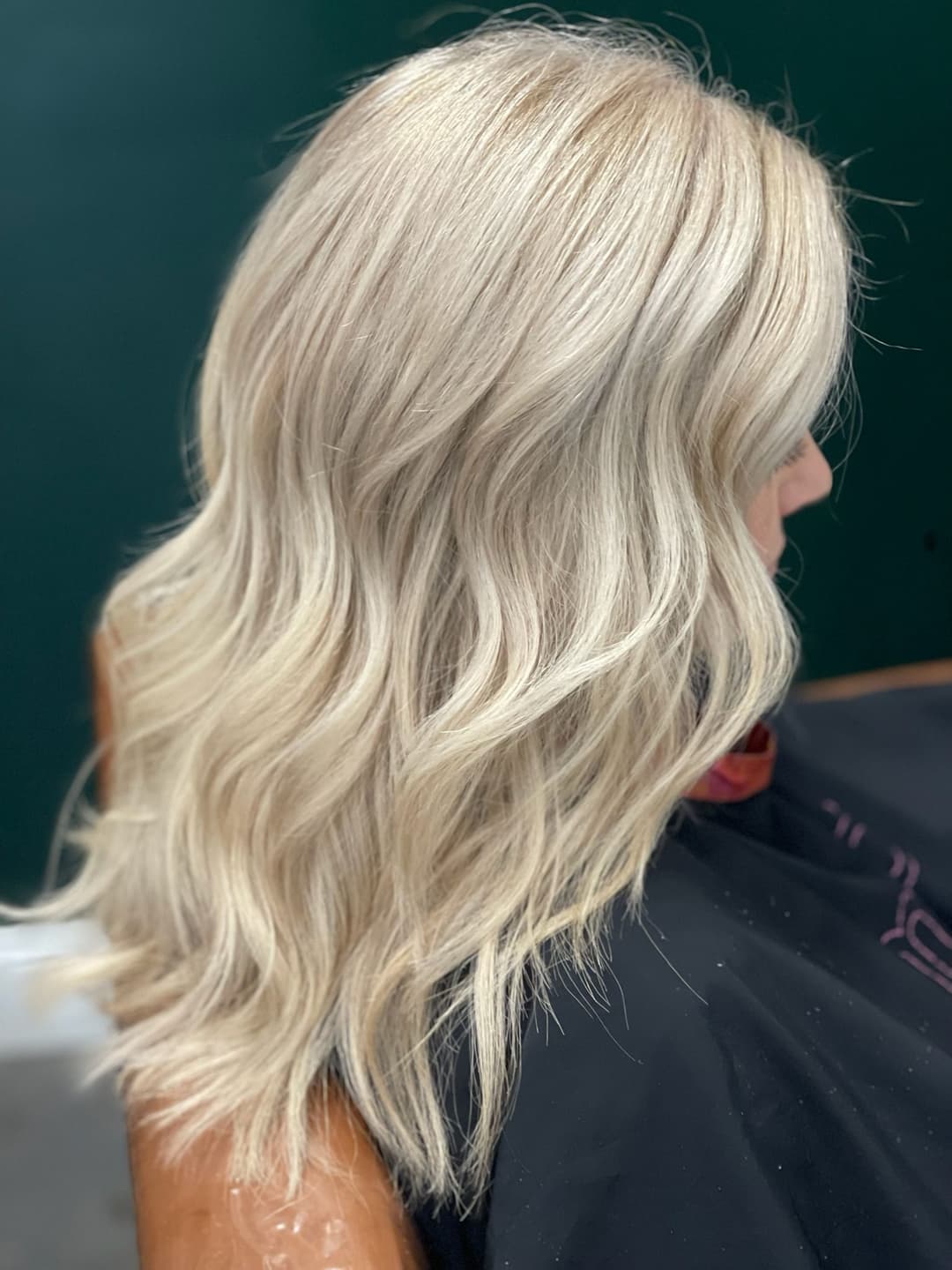 Blonde wavy hairstyle with layers, showcasing shiny, healthy hair texture.