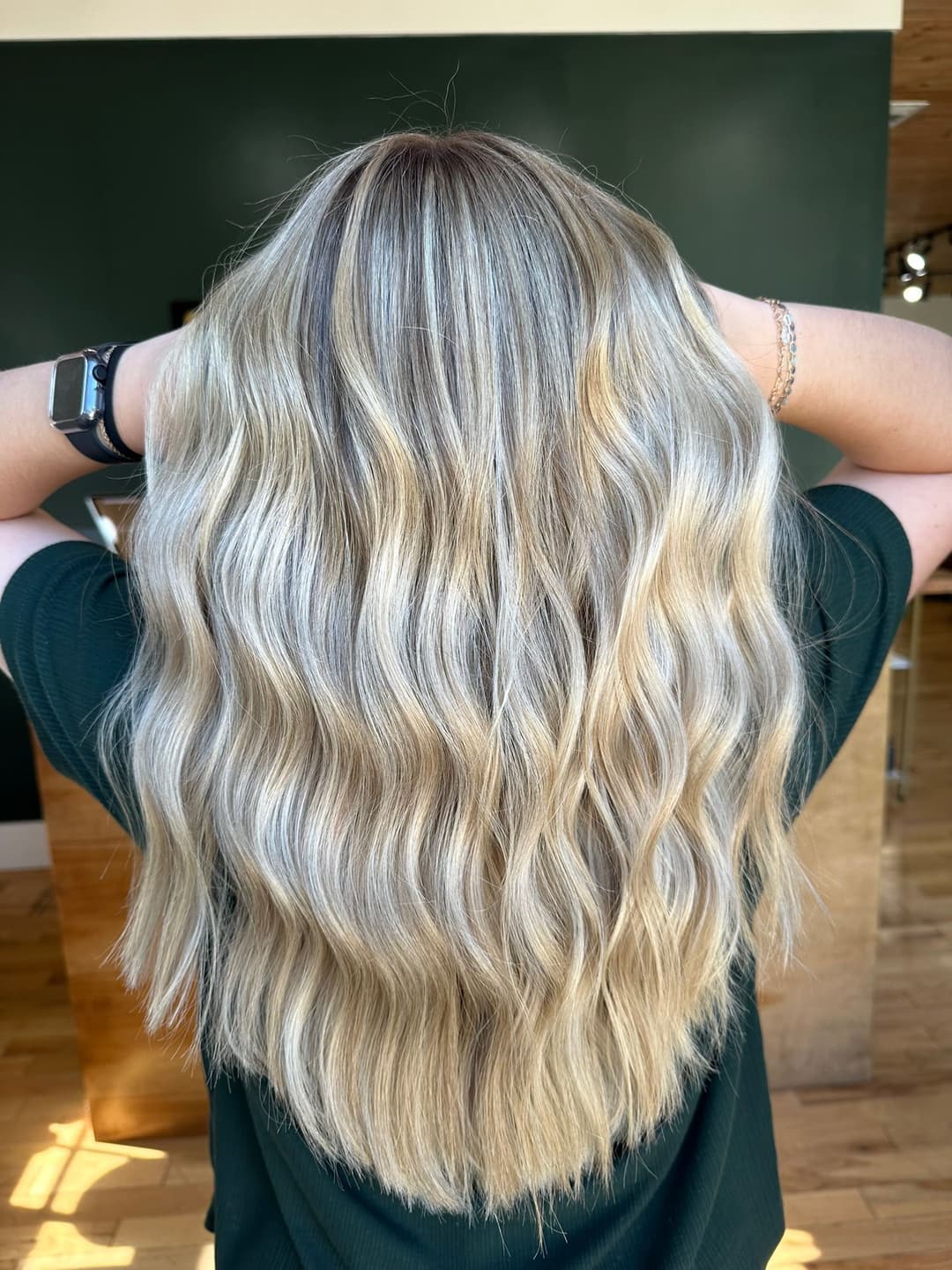 Woman with long, wavy blonde hair held back, showcasing a stylish hair color and texture.