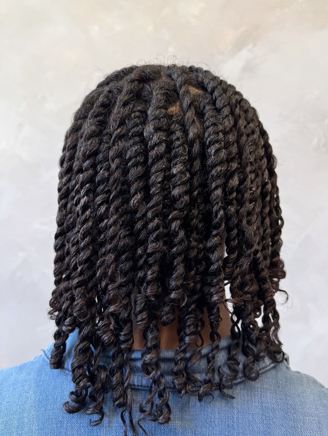 Person with neatly twisted natural hair, showcasing defined curls and healthy texture.