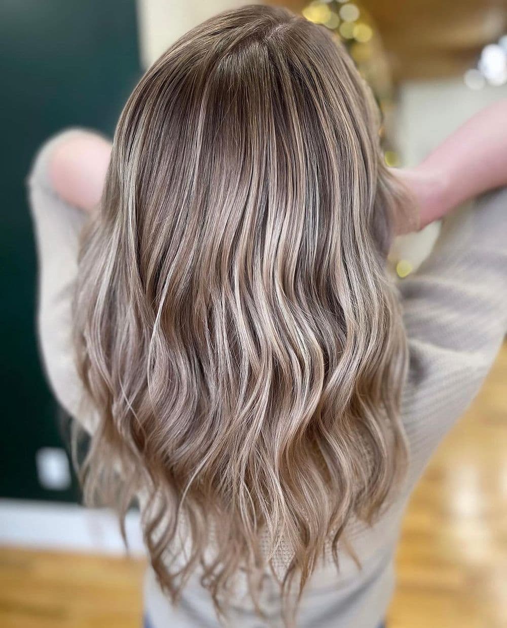 Long, wavy brunette hair with blonde highlights, styled elegantly from behind.
